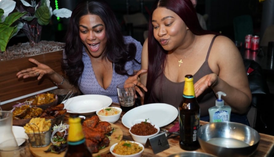 Friends sharing dishes at Uwagboe's Kitchen & Grill